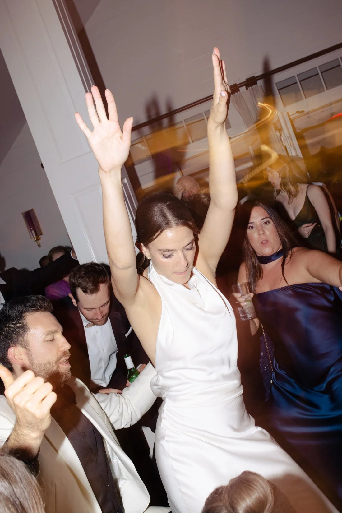 Bride dancing with hands in the air during lively reception at Peconic Bay Yacht Club