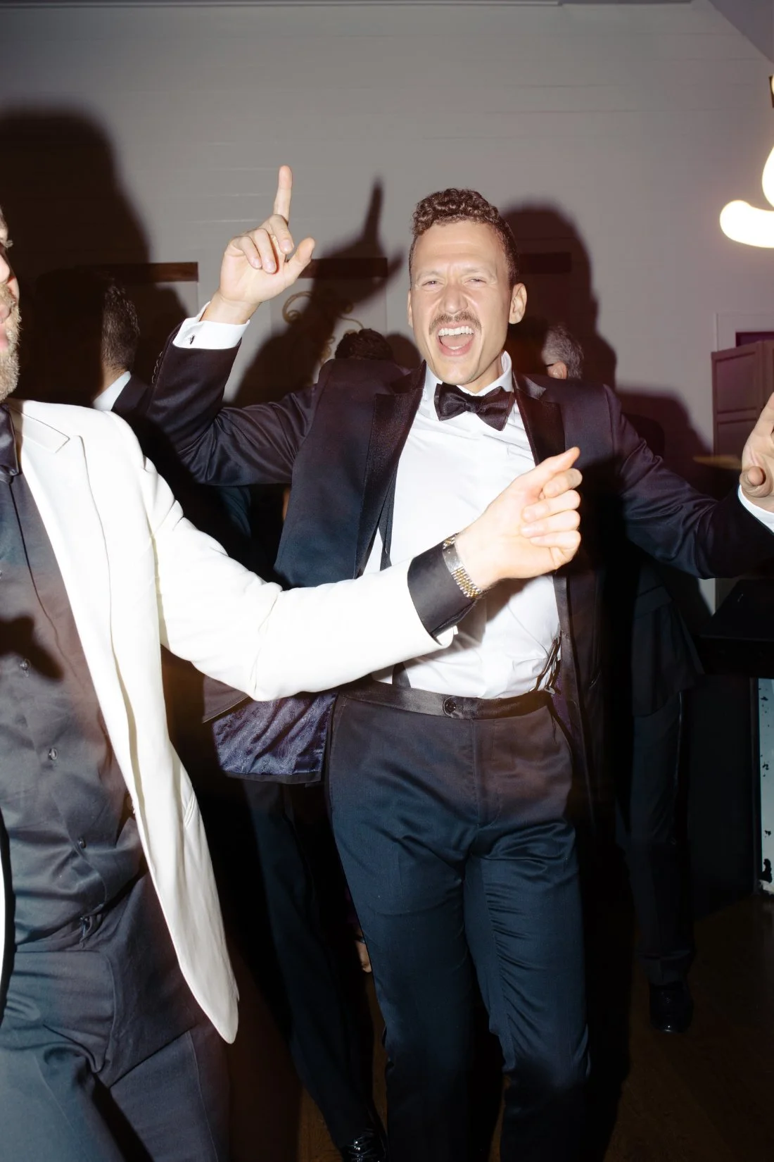 Groomsmen with hands in the air dancing on the dance floor at Peconic Bay Yacht Club