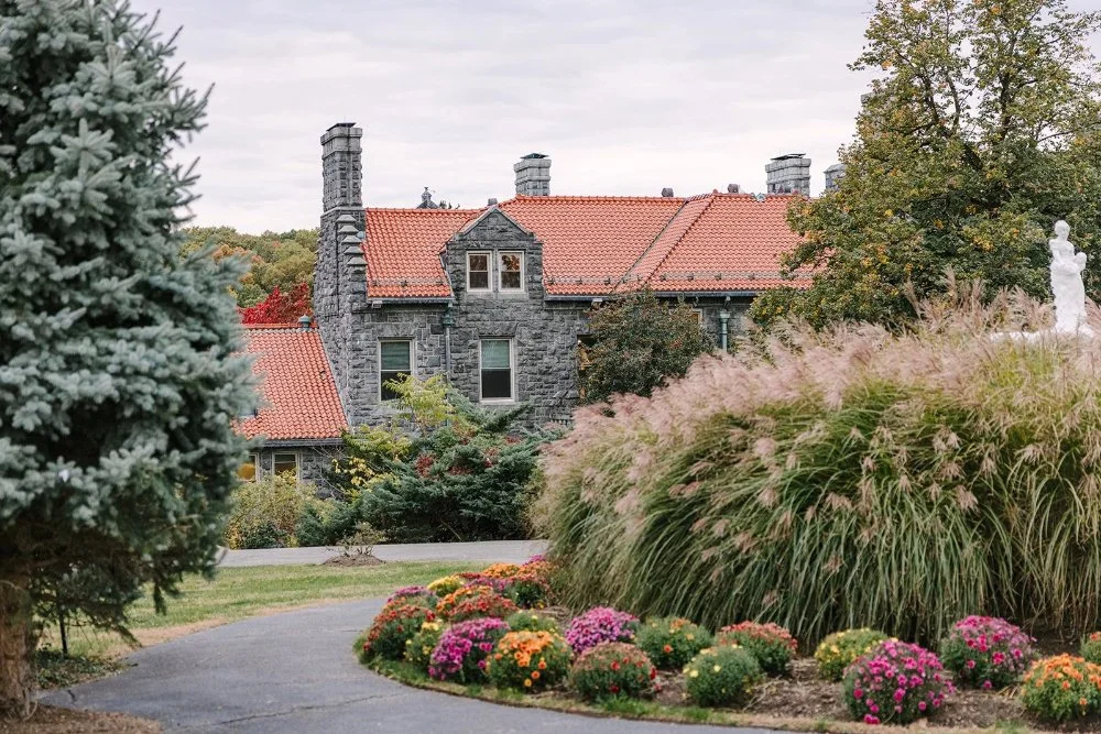 Exterior view of stone mansion and gardens at a Tarrytown House Estate wedding in the fall