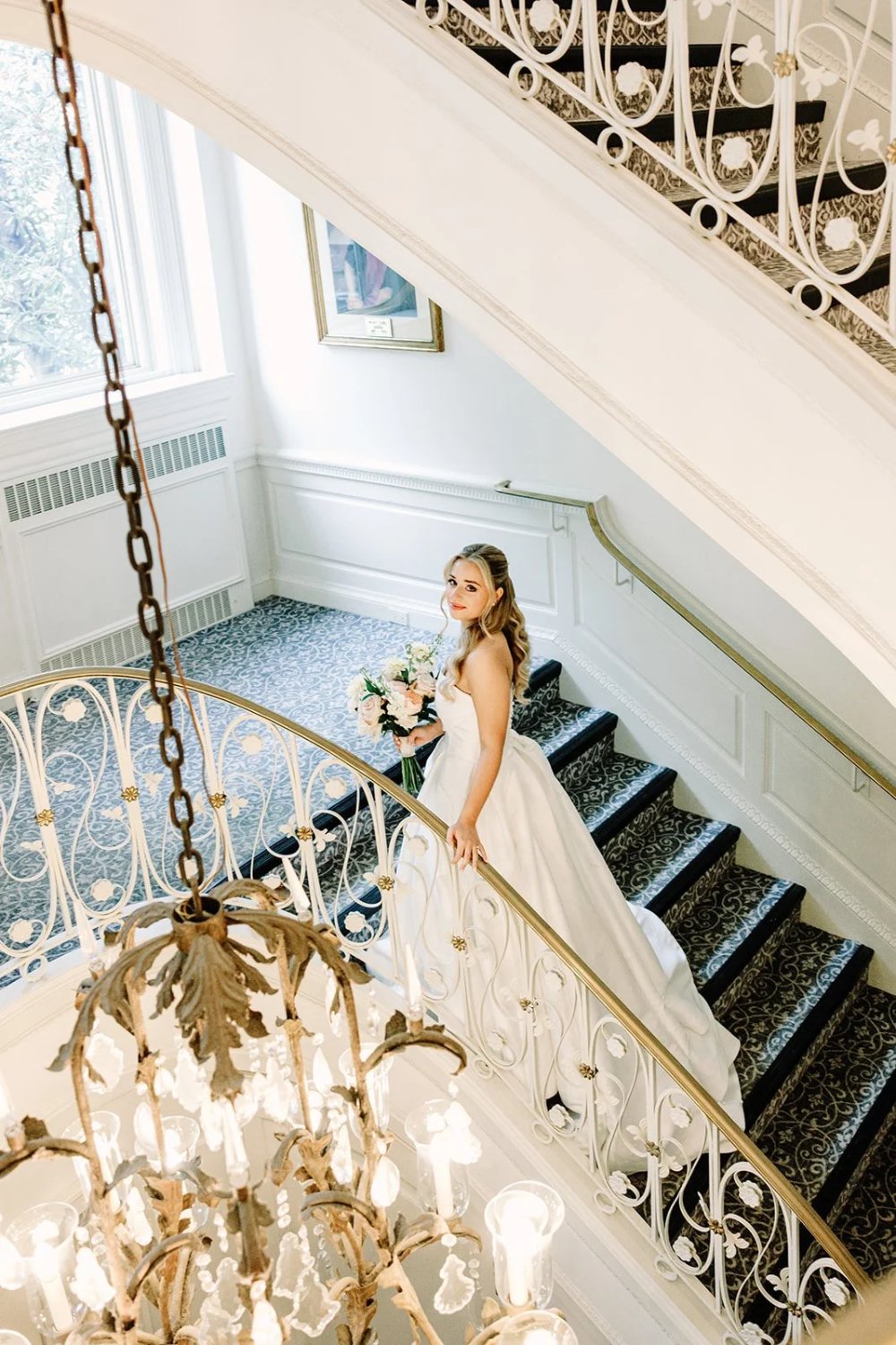 Bride on grand staircase inside venue during a Tarrytown House Estate wedding