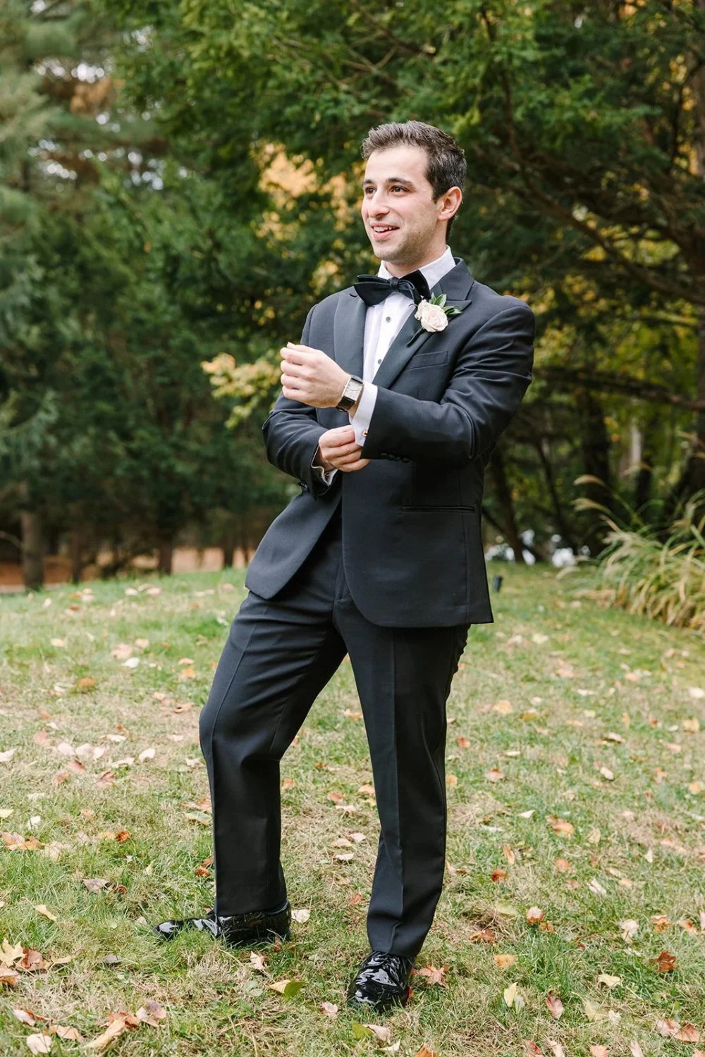 Groom adjusting cufflinks outdoors before ceremony at a Tarrytown House Estate wedding