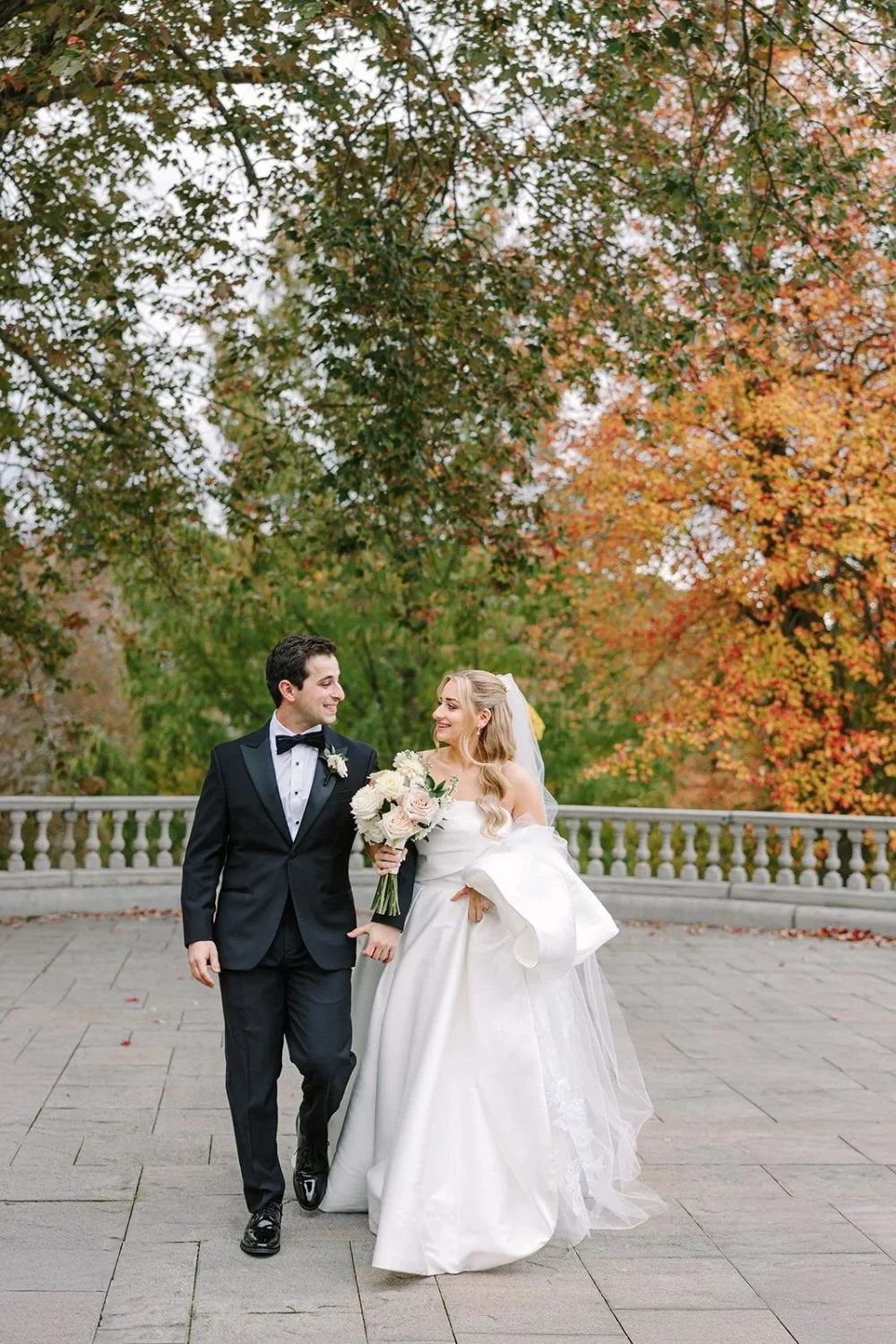 Couple walking together on terrace during a Tarrytown House Estate wedding with fall colors