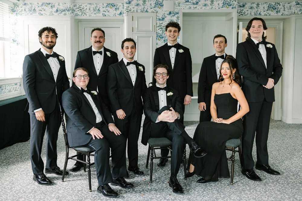 Groom and groomsmen in black tuxedos posing indoors at a Tarrytown House Estate wedding