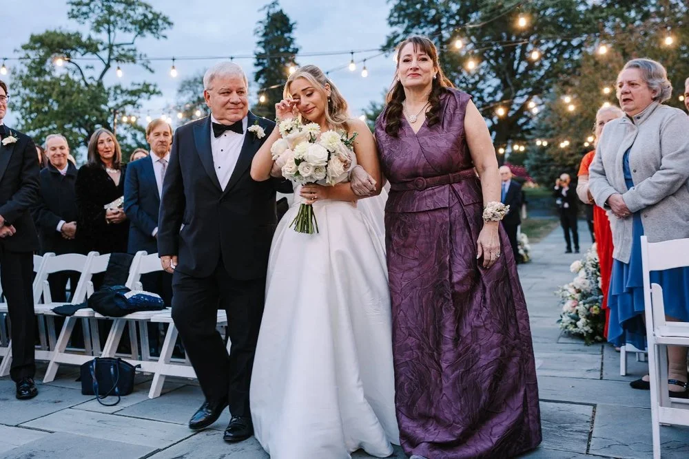 Bride walking down the aisle with her parents during Tarrytown NY outdoor wedding ceremony