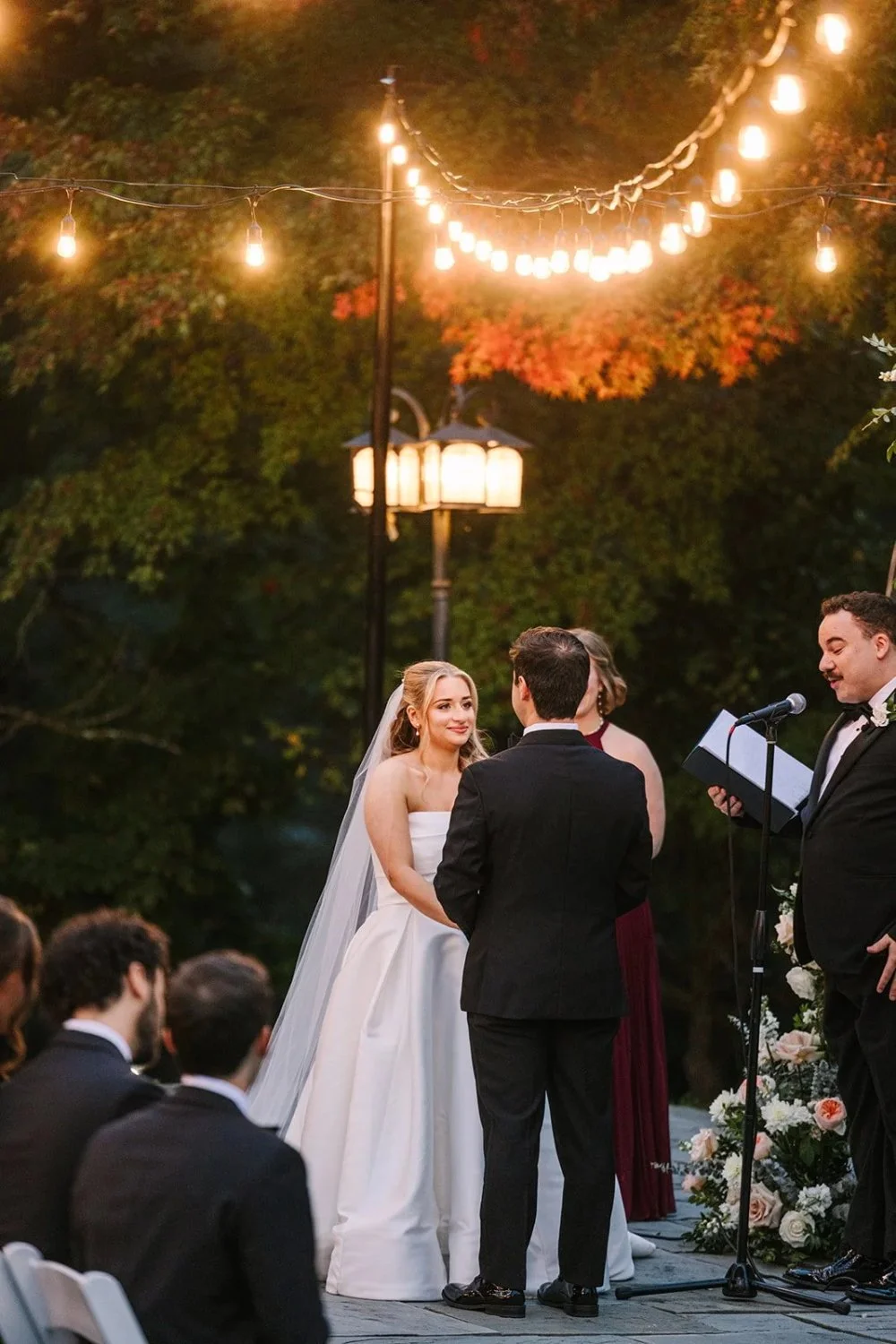 Couple exchanging vows under glowing lights at Tarrytown NY outdoor wedding