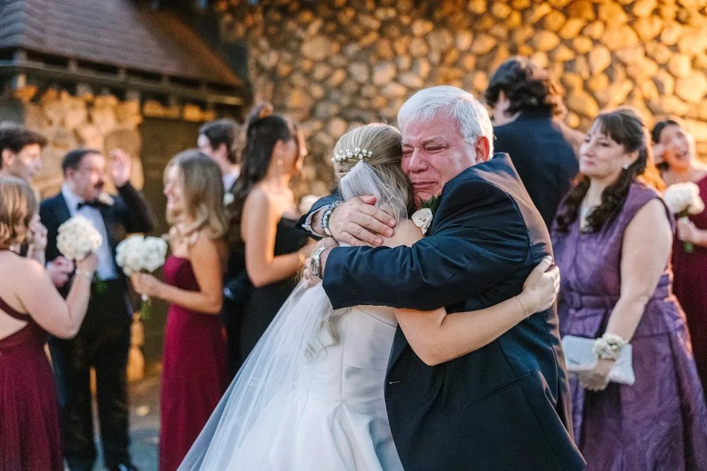 Father hugging bride emotionally during reception moment