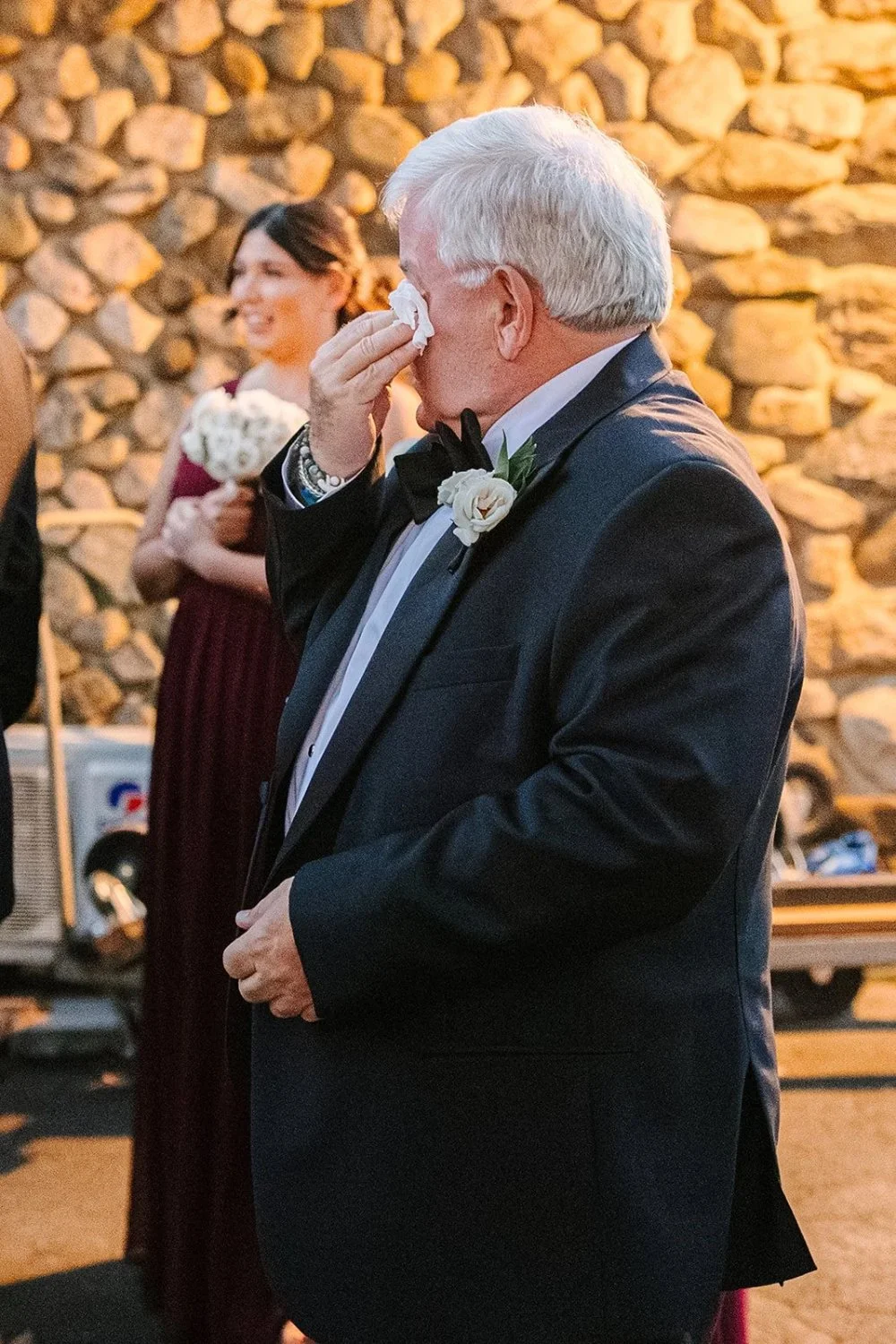 Father wiping away tears during heartfelt wedding celebration moment