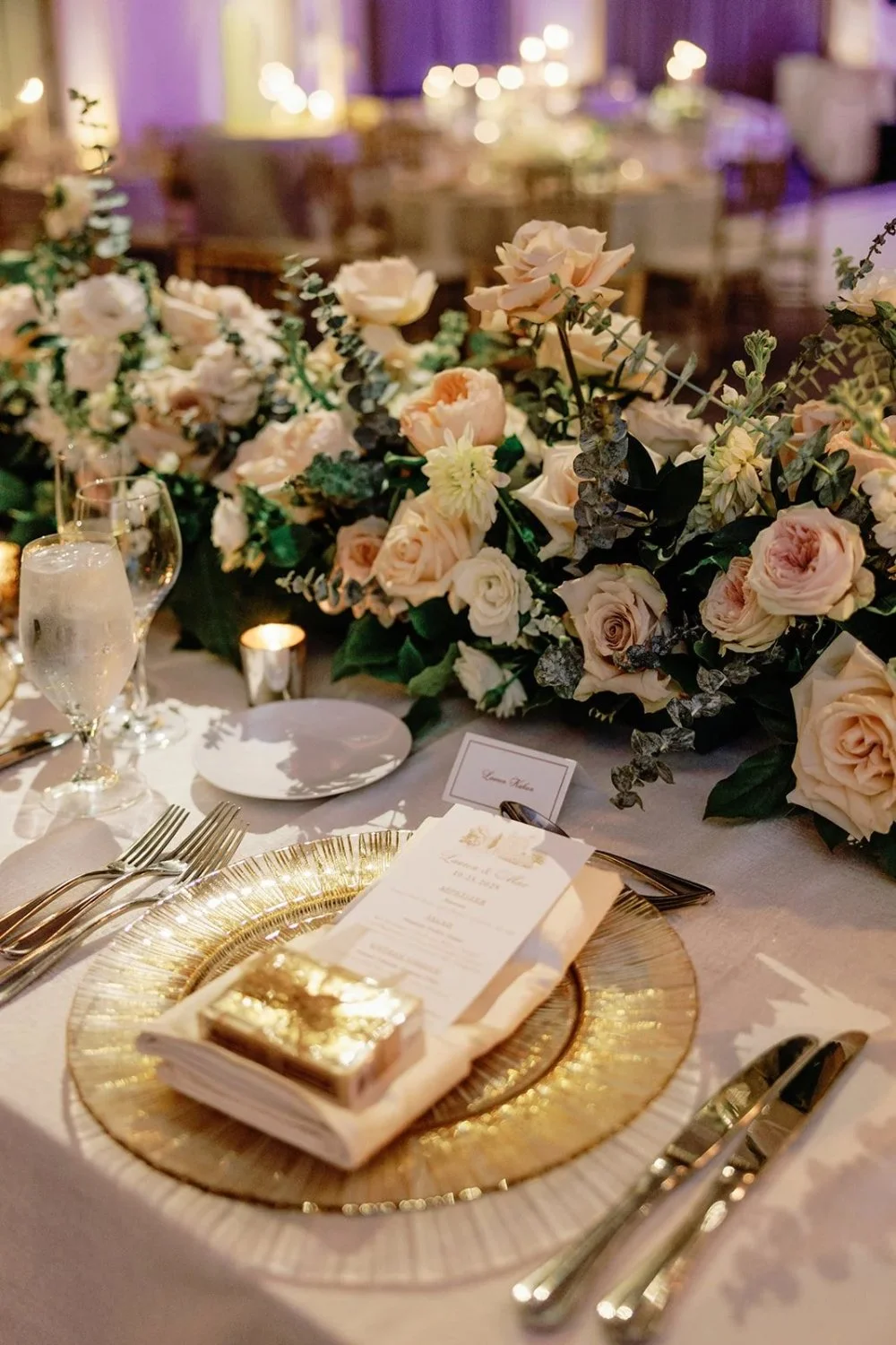 Gold charger place setting with menu card and floral runner centerpiece