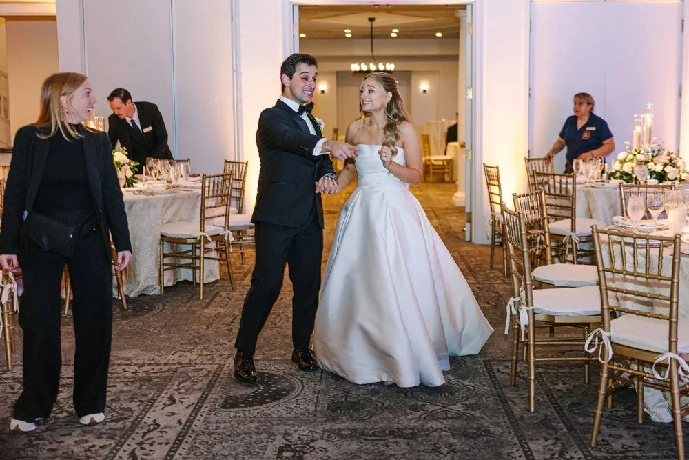 Couple entering reception smiling and reacting to their decorated space