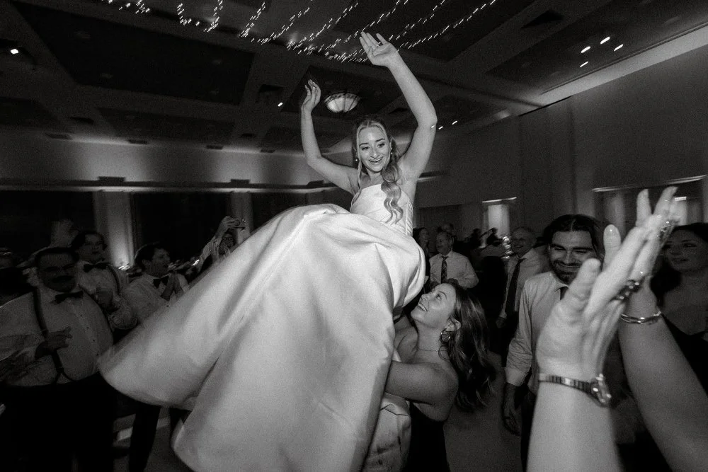Bride lifted in the air during energetic dance floor moment
