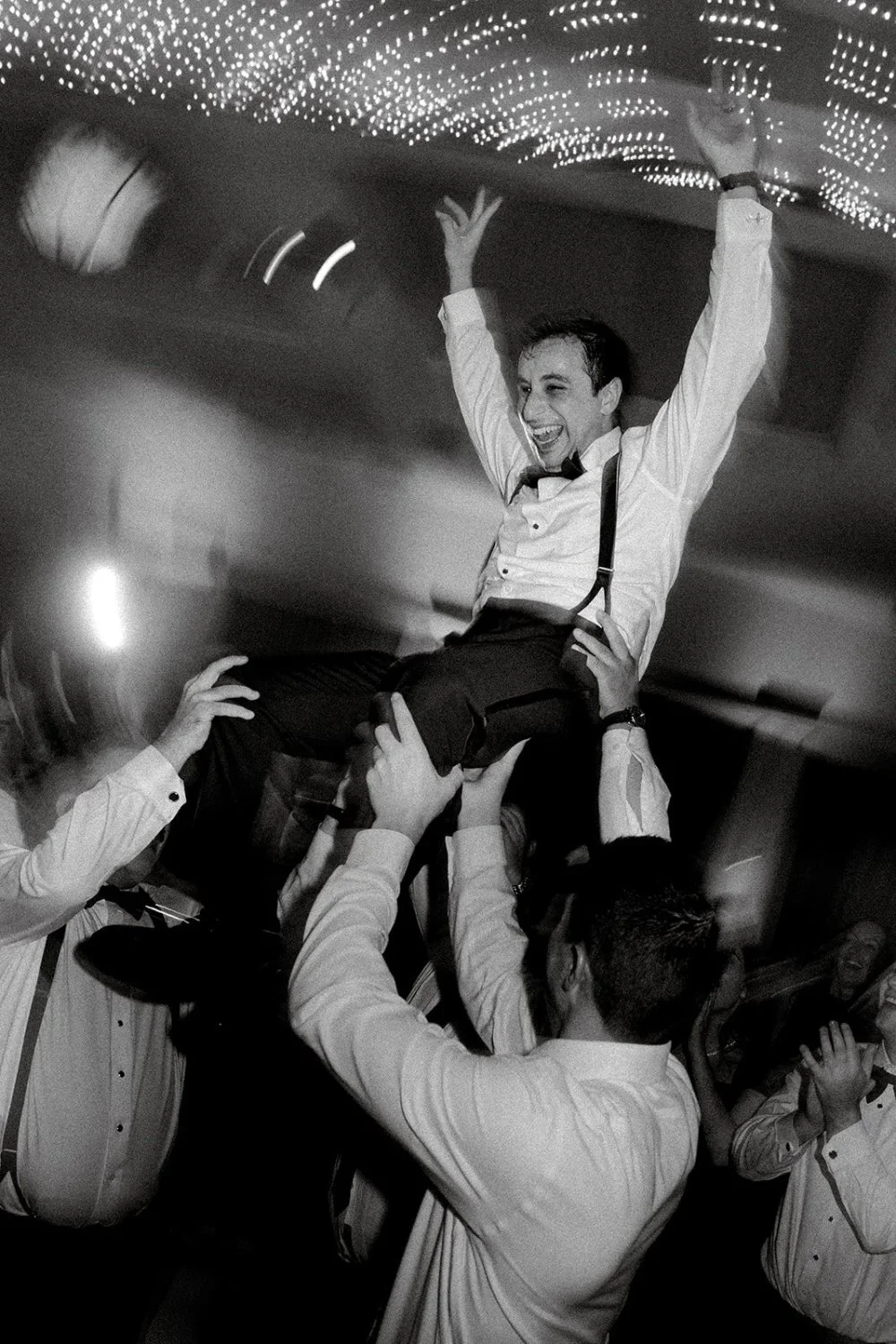 Groom lifted into the air by friends during reception dance party at Tarrytown NY outdoor wedding