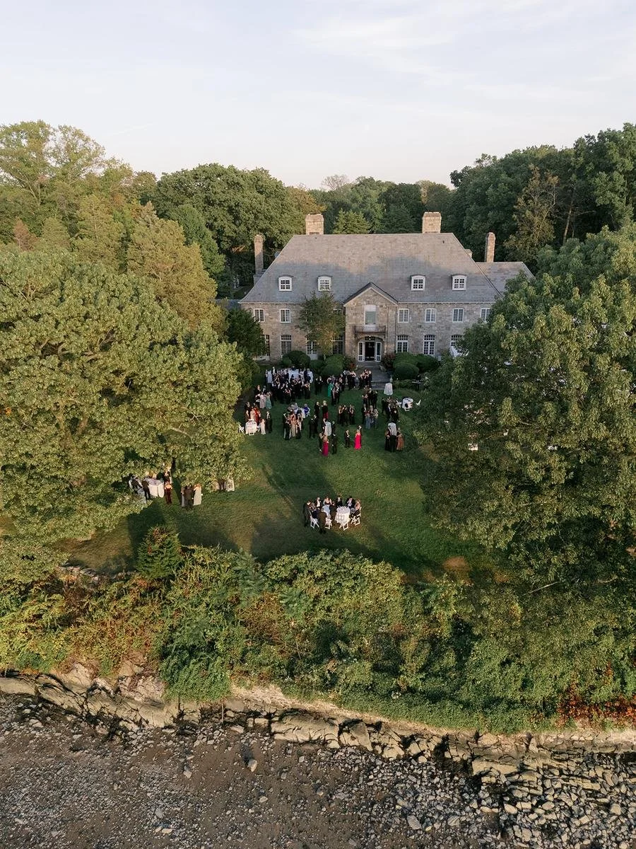 Aerial view of the ceremony site featuring a floral-covered chuppah and waterfront backdrop at a beautiful Wainwright House wedding.