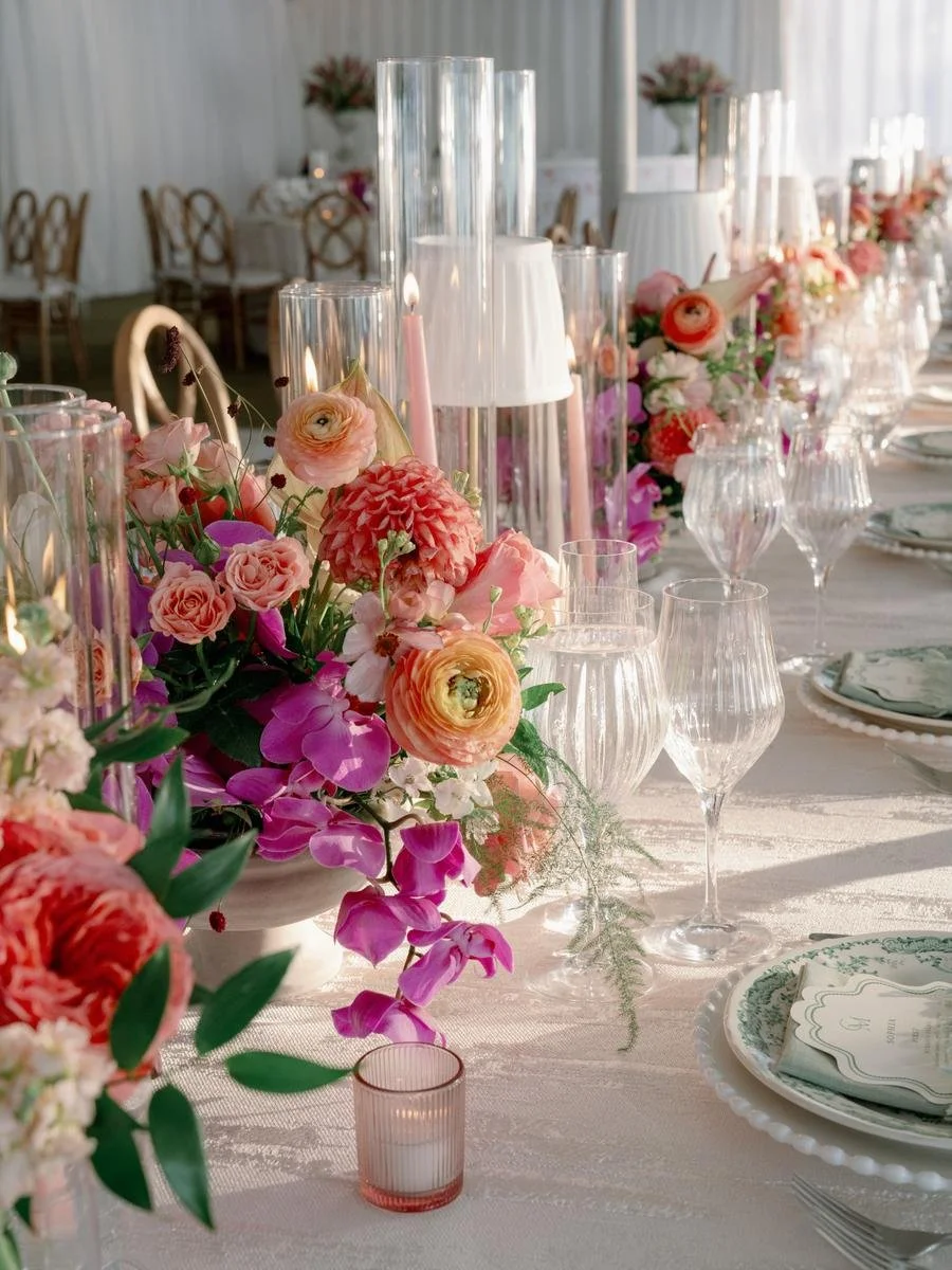 Long reception table featuring colorful floral arrangements and candlelight at a Wainwright House wedding.