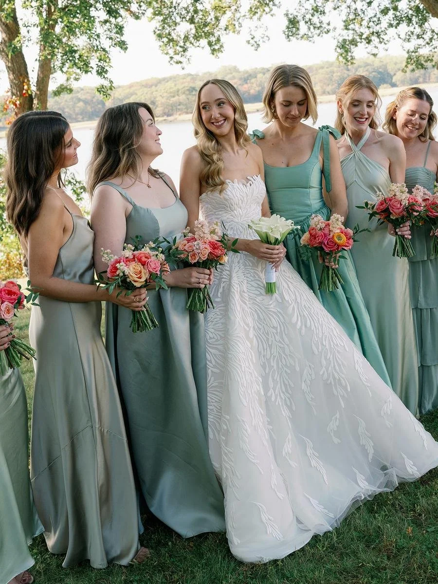 Bride posing with her bridesmaids along the waterfront during a Wainwright House wedding celebration.