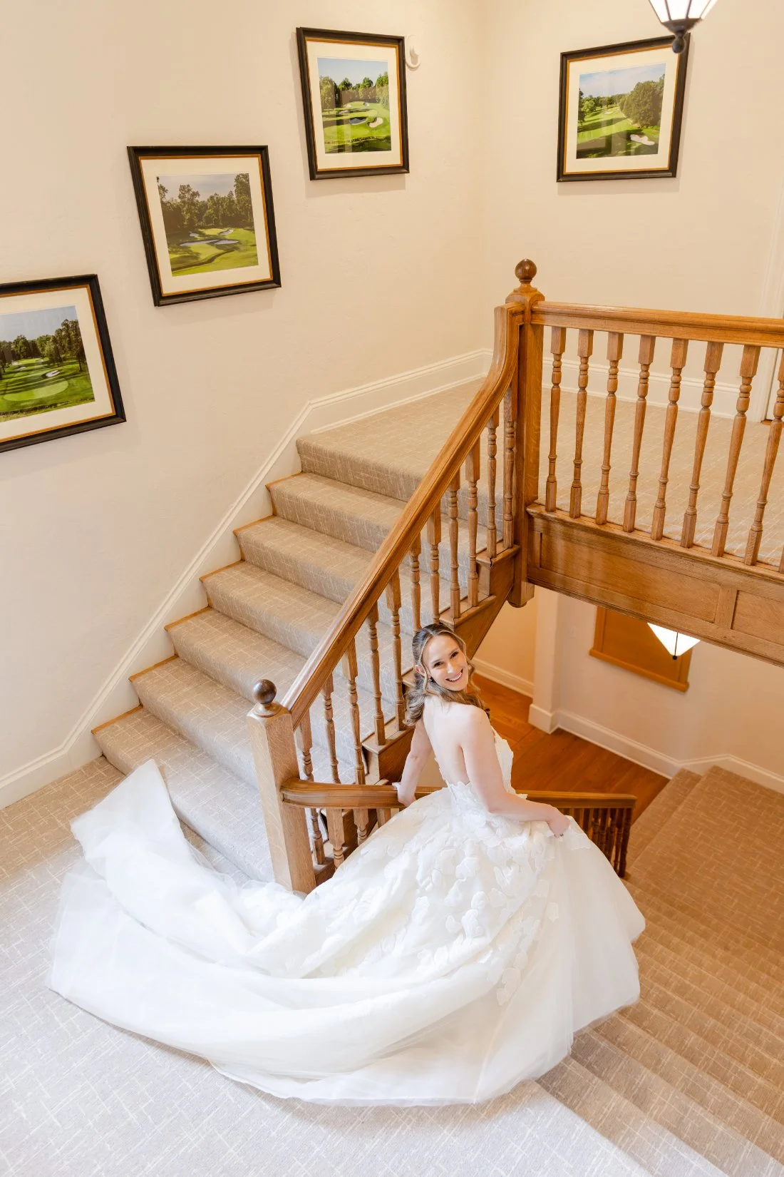 Bride showing the dramatic train of her gown on the staircase at Quaker Ridge Golf Club