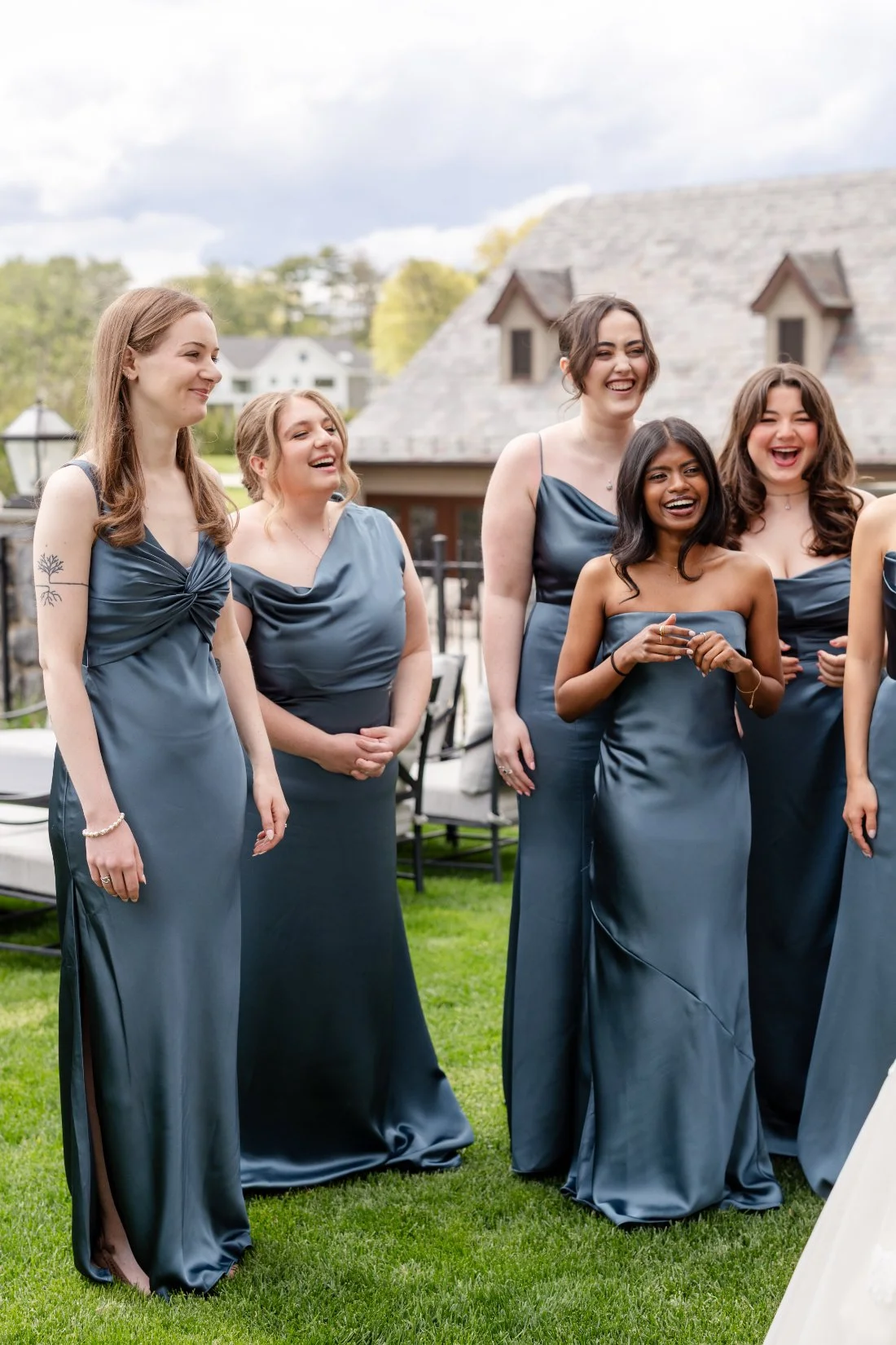 Bridesmaids laughing together in dusty blue dresses at a spring Westchester wedding