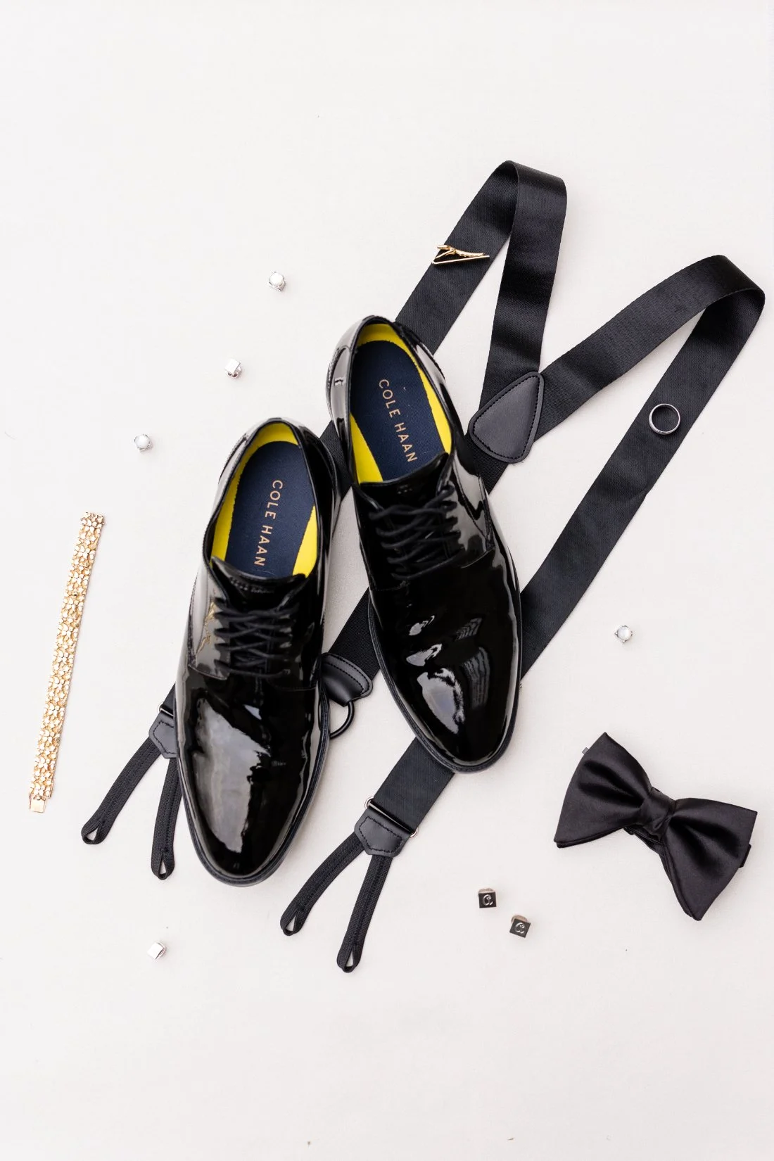 Groom’s black patent leather wedding shoes, suspenders, bow tie, cufflinks, and accessories styled for a Quaker Ridge Golf Club wedding in New York.