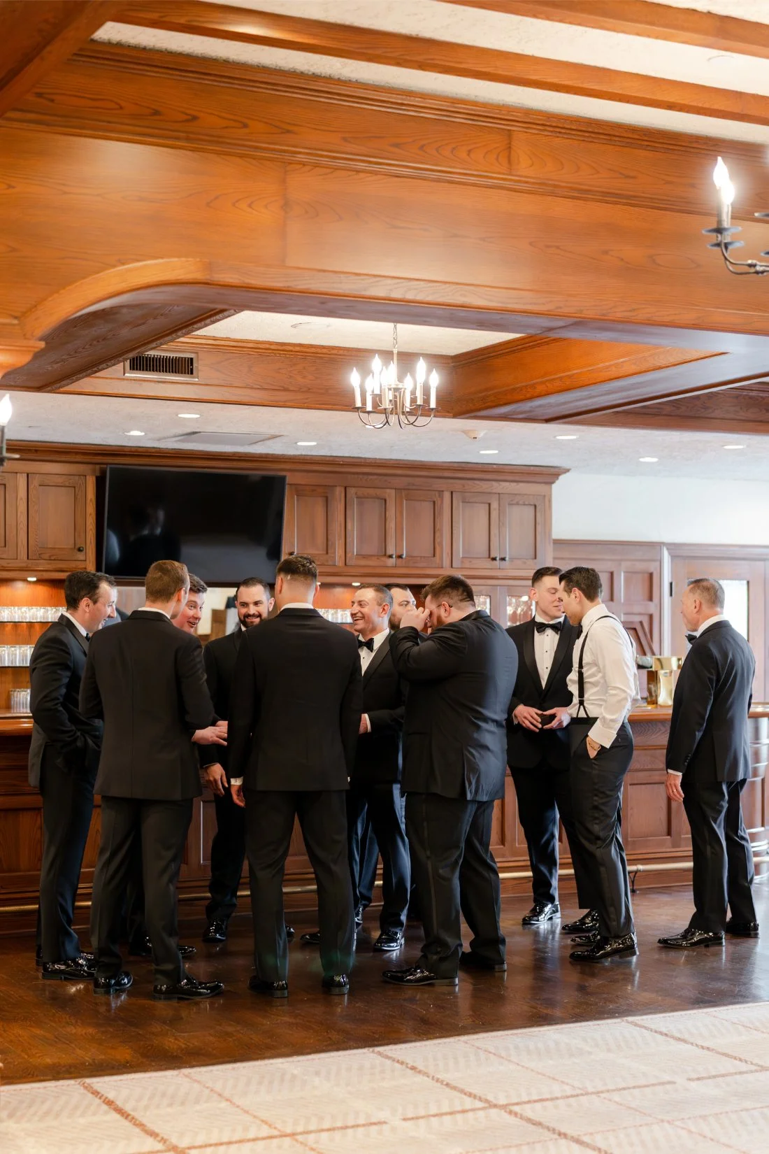 Groom and groomsmen gathering together at the bar before a Quaker Ridge Golf Club wedding in New York.