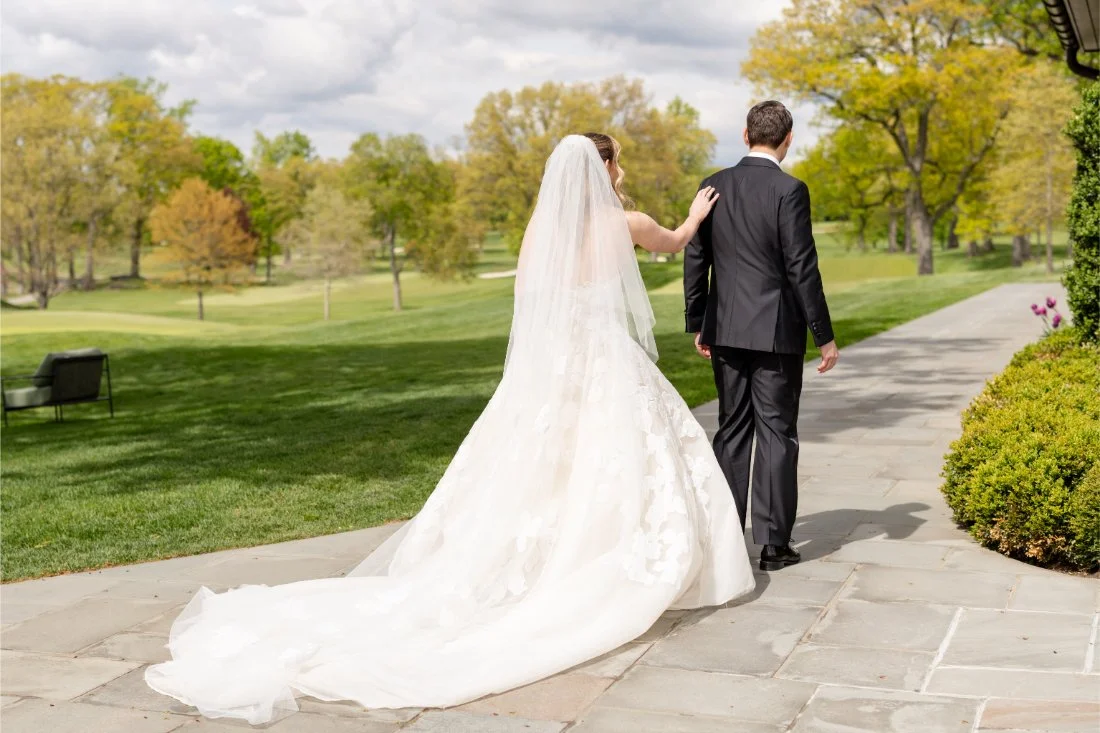 Bride taps groom on the shoulder during their outdoor wedding day first look