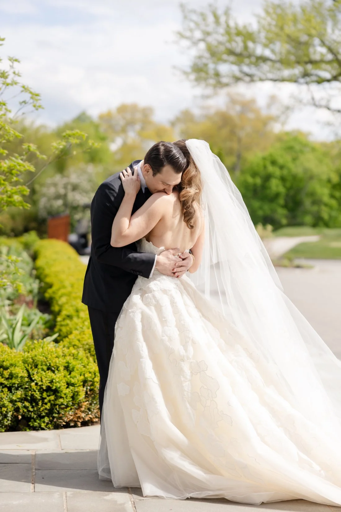 Newlyweds embrace during romantic Quaker Ridge Golf Club wedding portraits