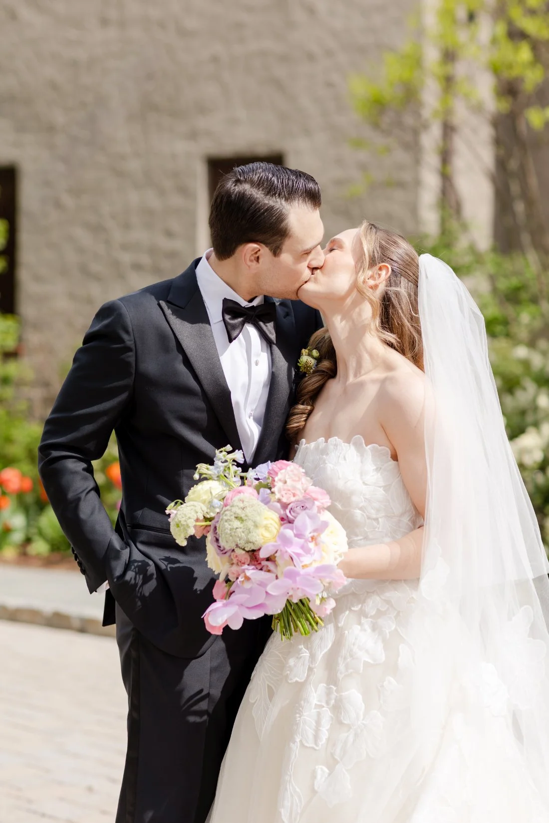 Bride and groom kiss during romantic Quaker Ridge Golf Club wedding portraits