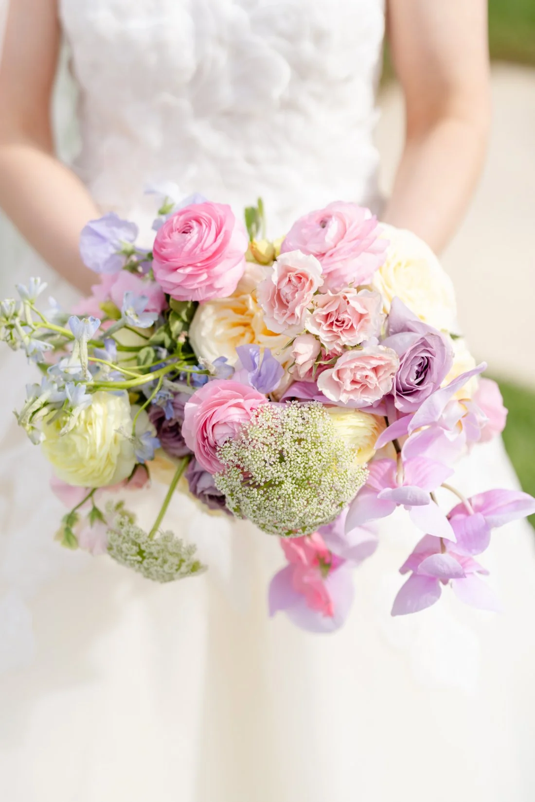 Colorful bridal bouquet with pink, lavender, ivory and soft blue spring flowers
