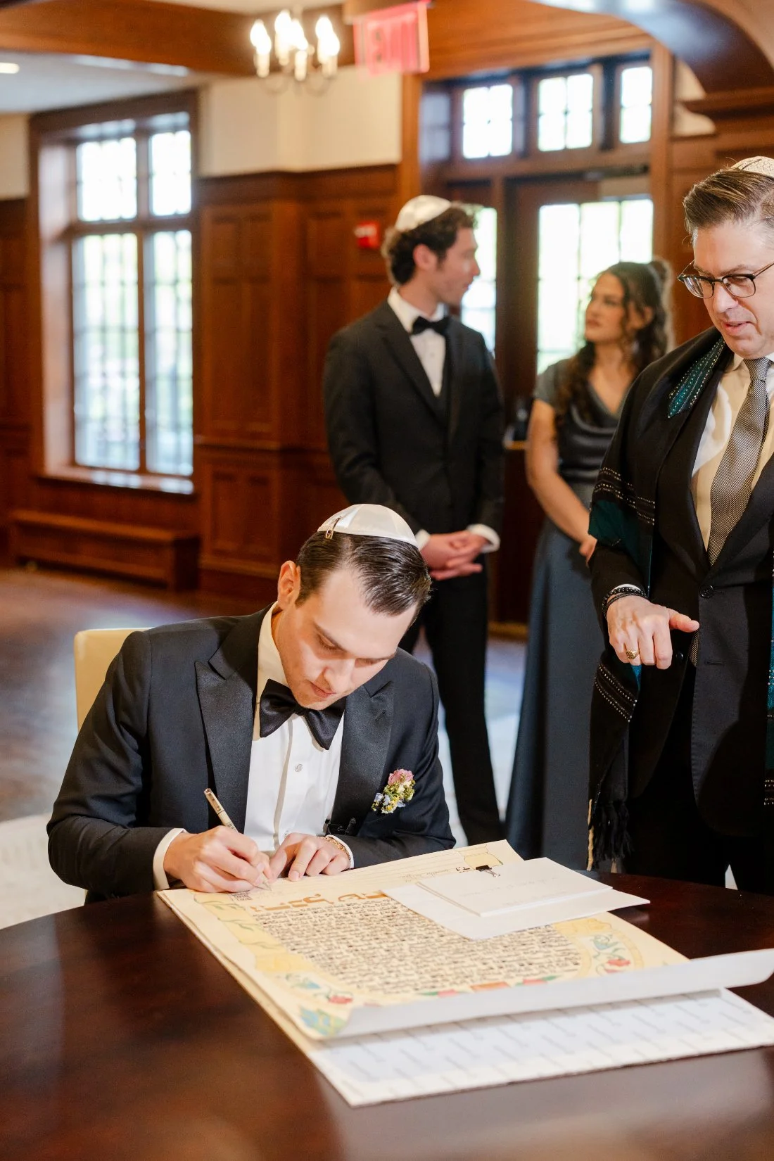 Groom signs the Ketubah alongside the rabbi before the Jewish wedding ceremony.