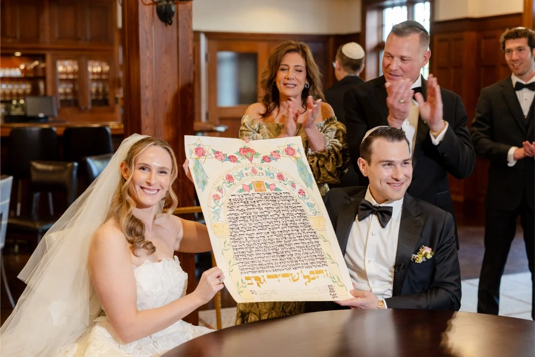 Bride and groom proudly hold their signed Ketubah before the wedding ceremony.
