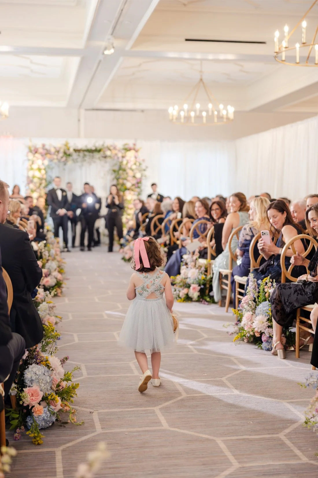 Flower girl walking down the aisle during the wedding ceremony.