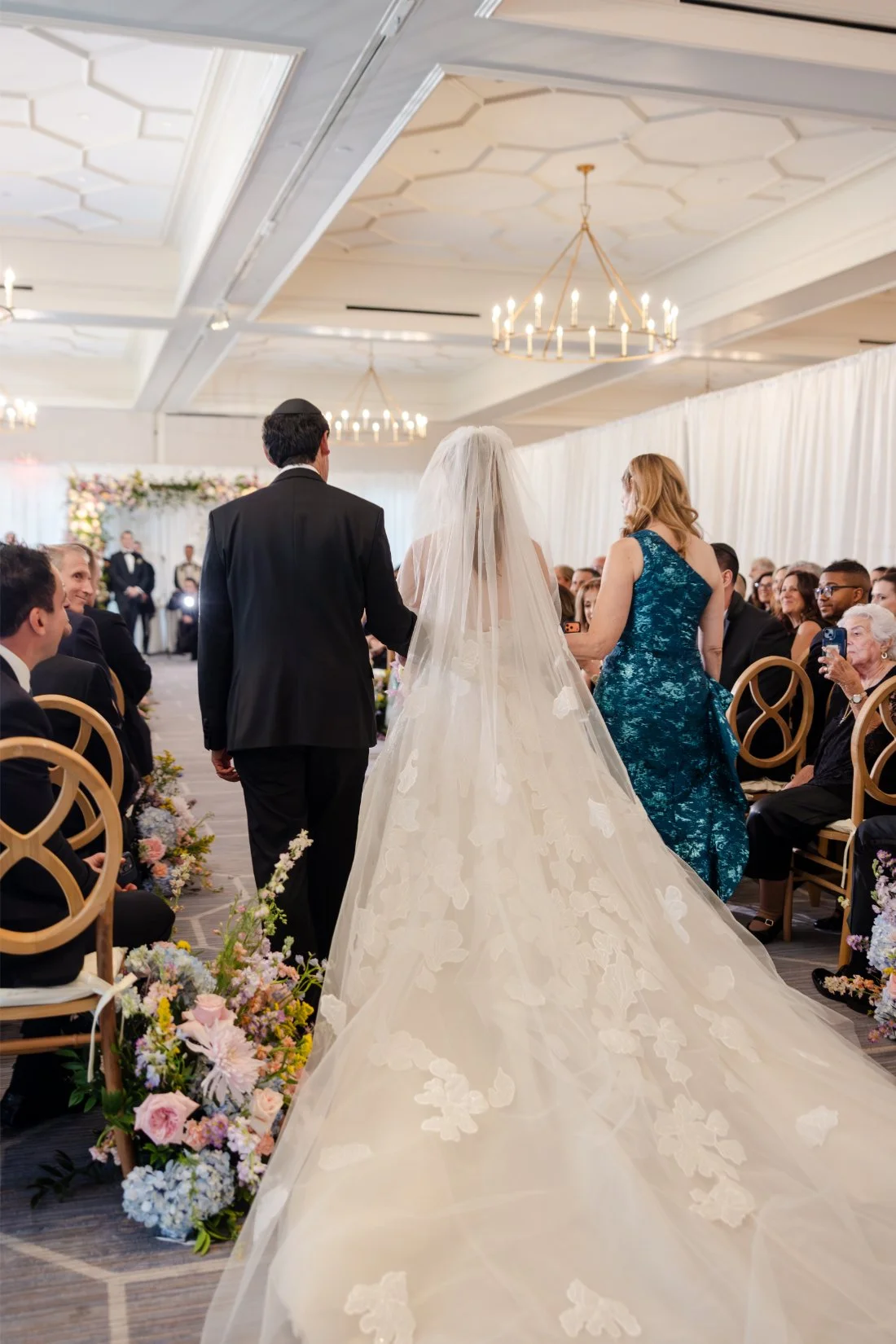 Bride entering her Quaker Ridge Golf Club wedding ceremony, photographed from behind.