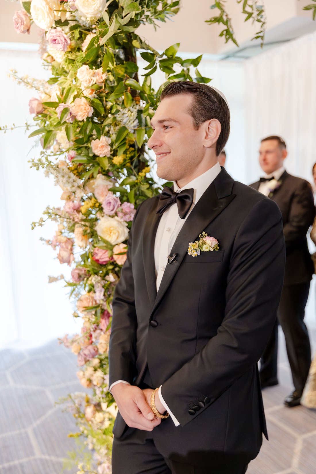 Groom smiling as he sees his bride coming down the aisle.