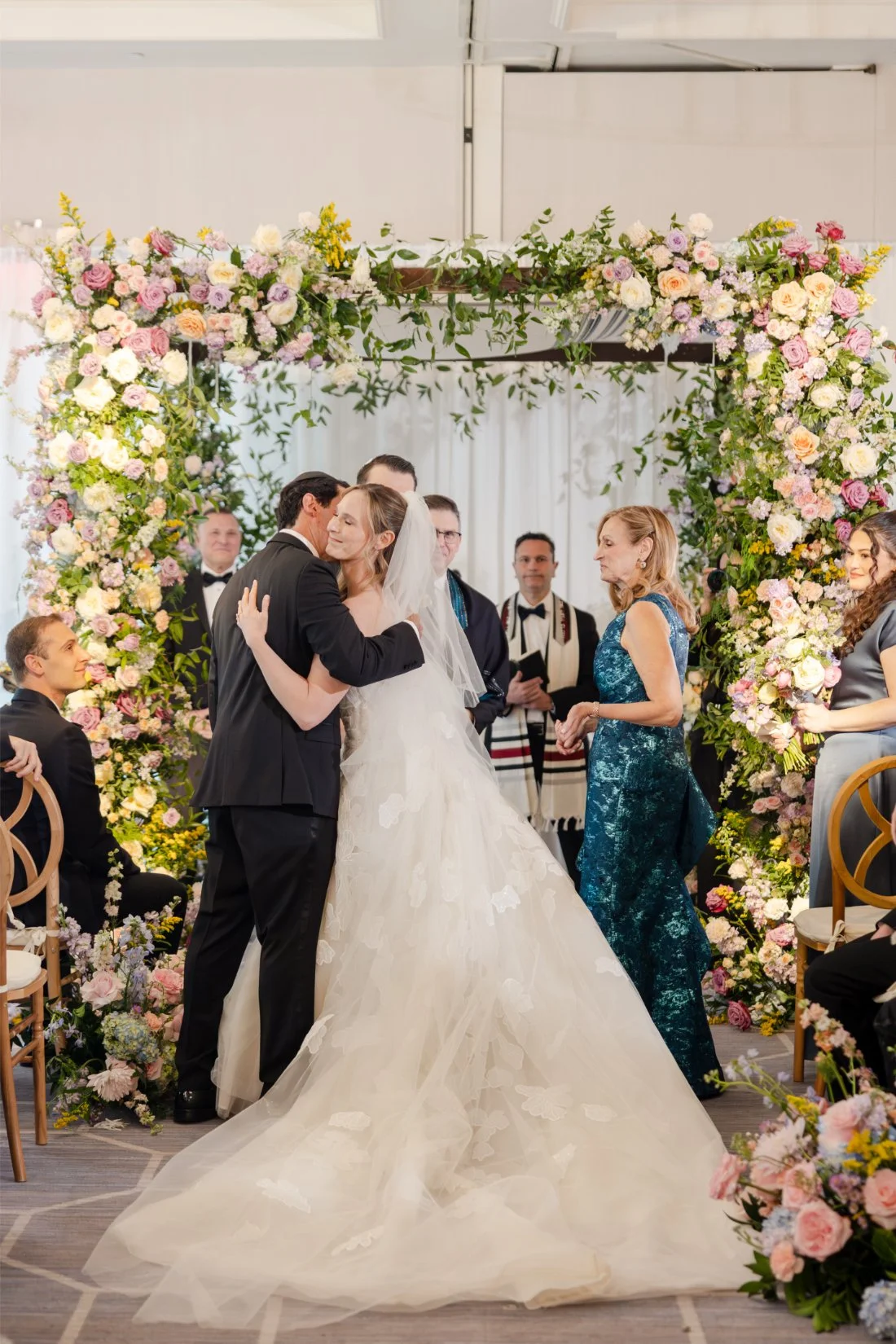 Bride kissing her father as her parents give her away at the ceremony.