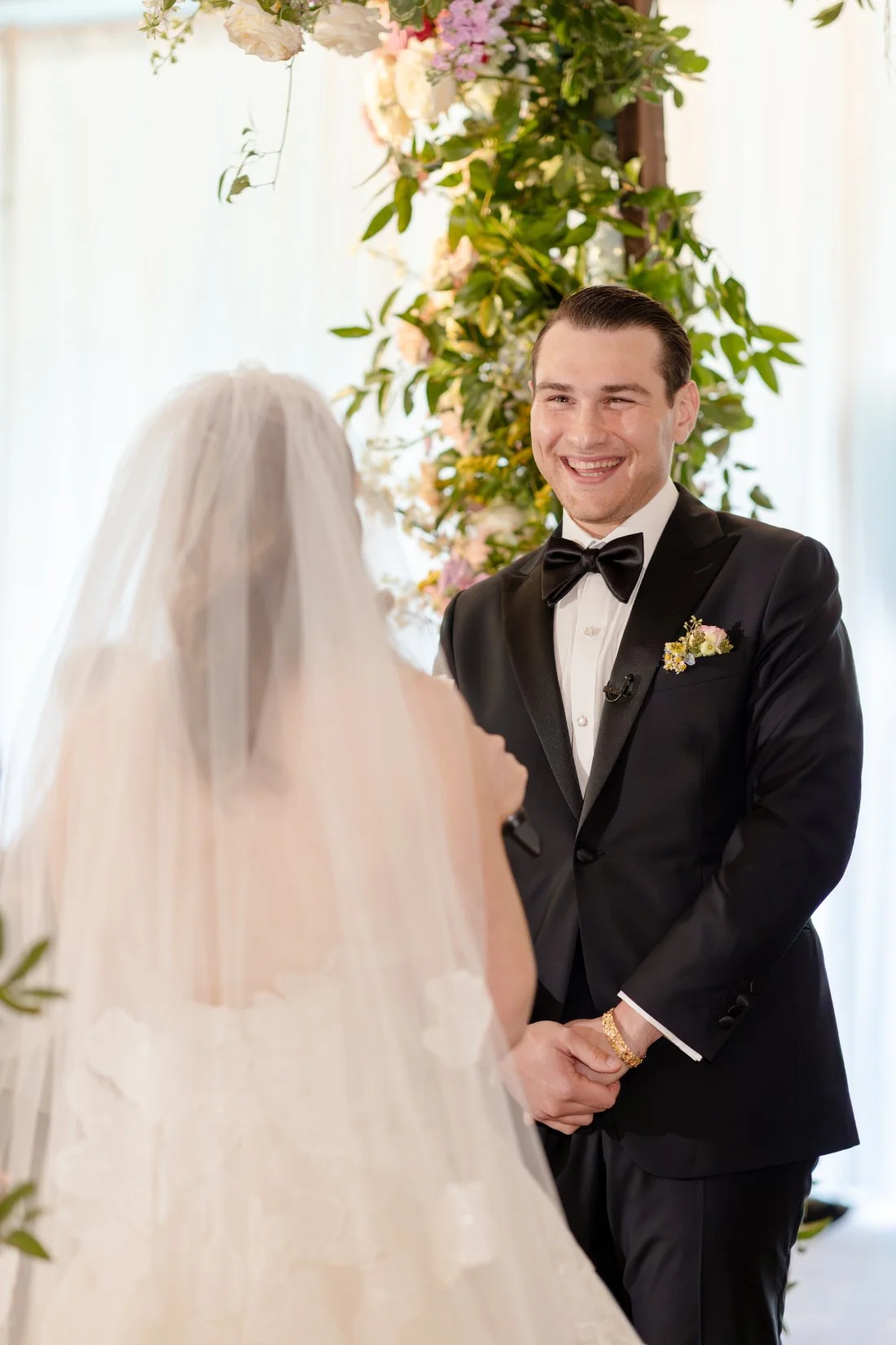 Groom smiling at his bride during their Quaker Ridge Golf Club wedding ceremony.