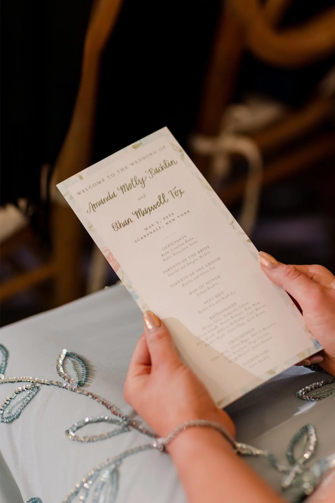 Wedding guest holding the couple’s ceremony program.