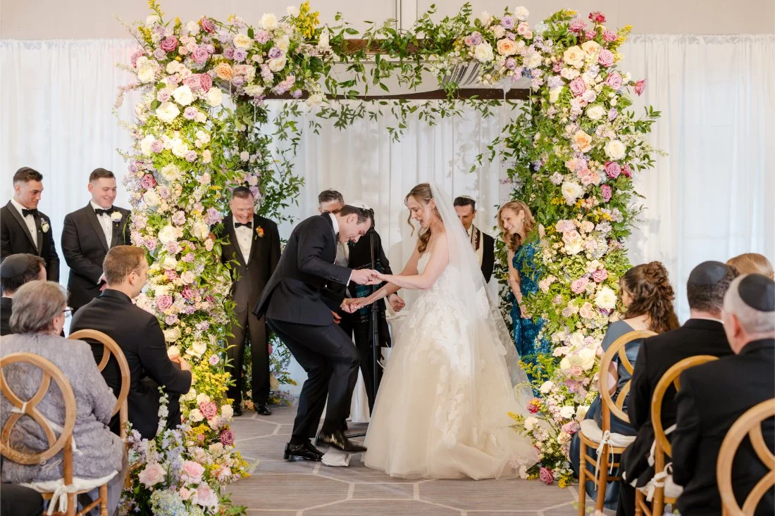 Groom breaking the glass during a Jewish Quaker Ridge Golf Club wedding ceremony.