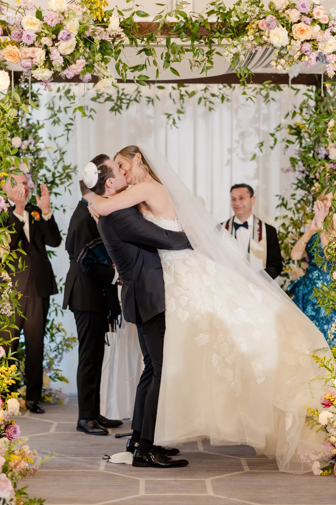 Groom lifting the bride in celebration after their wedding ceremony.
