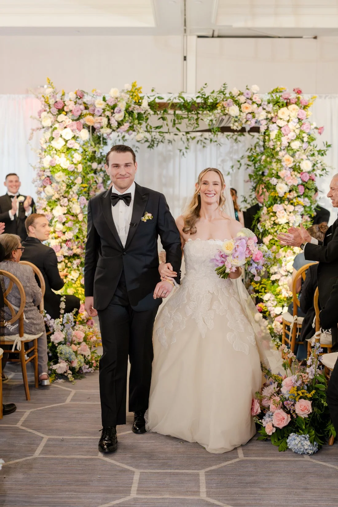 Newlyweds walking back down the aisle after their Quaker Ridge Golf Club wedding ceremony.