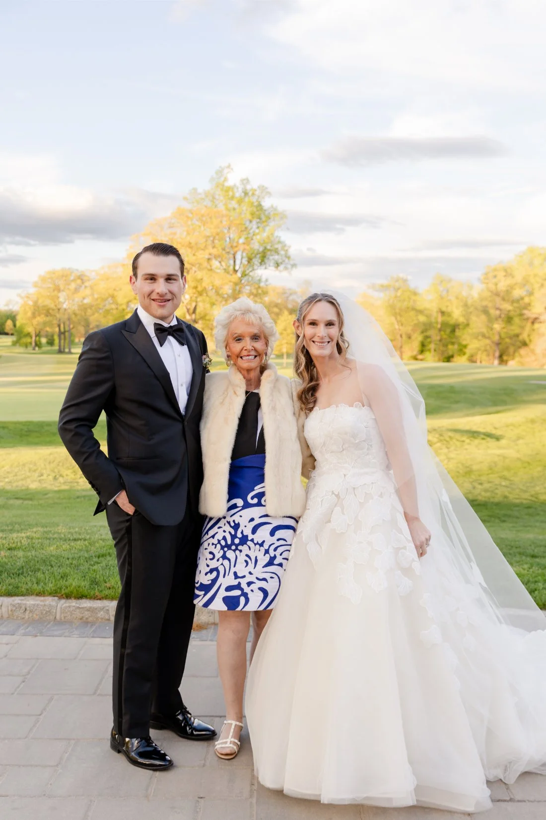 Bride and groom posing for a photo with a guest at their Quaker Ridge Golf Club wedding.