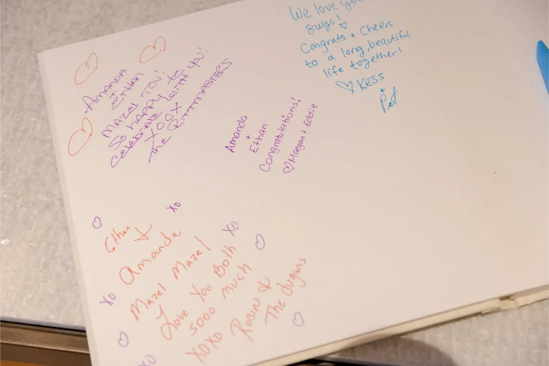 Wedding guest book displayed for guests to sign during cocktail hour.
