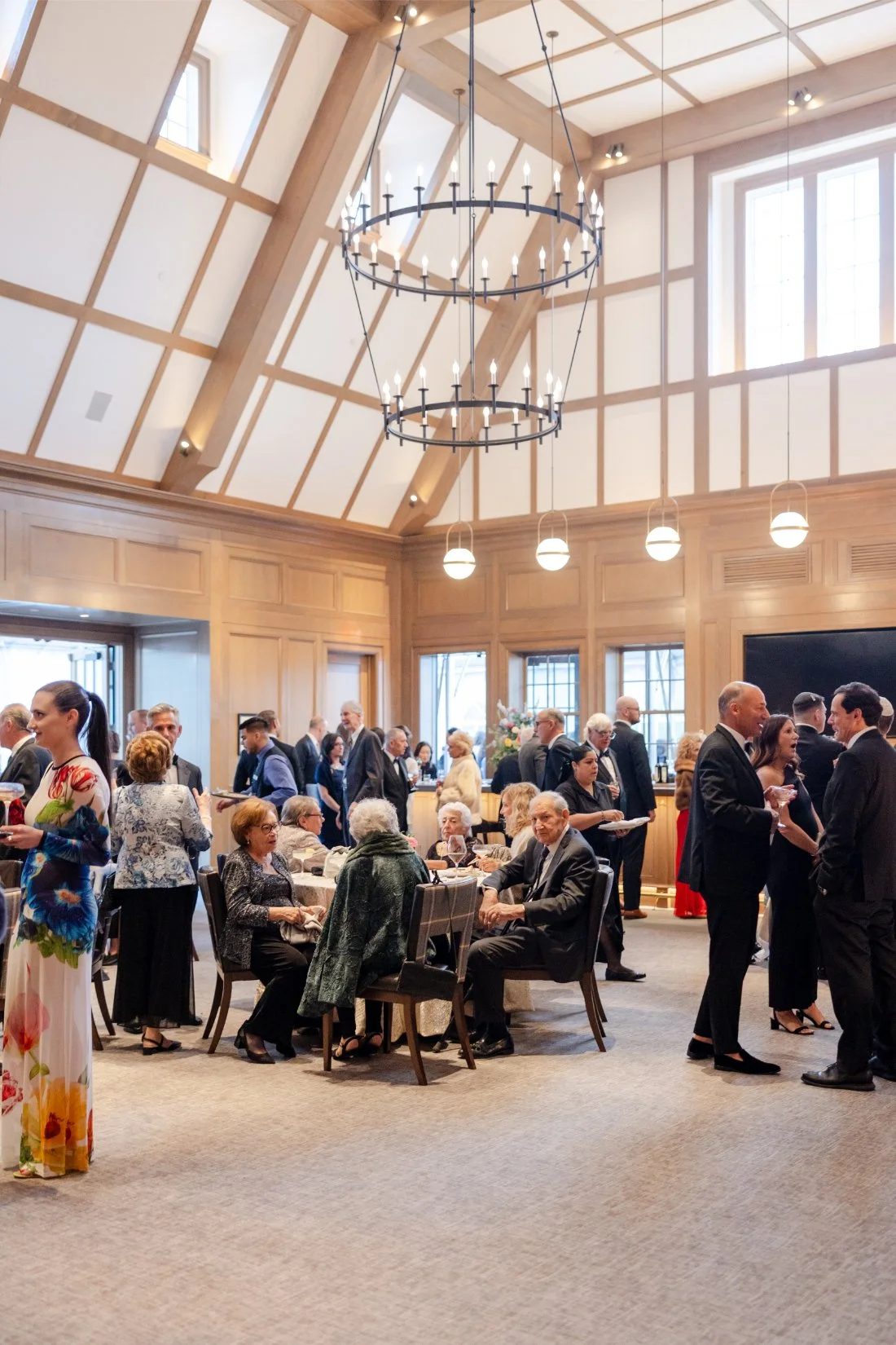Wide view of guests mingling during a Quaker Ridge Golf Club wedding cocktail hour.