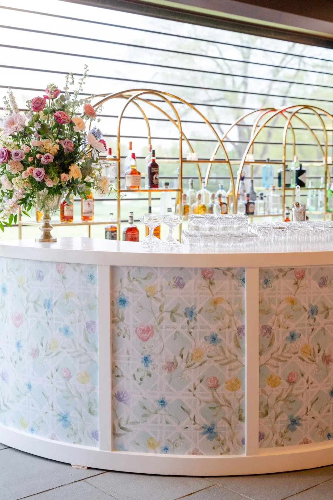 Bar setup decorated with colorful floral details at a Quaker Ridge Golf Club wedding.