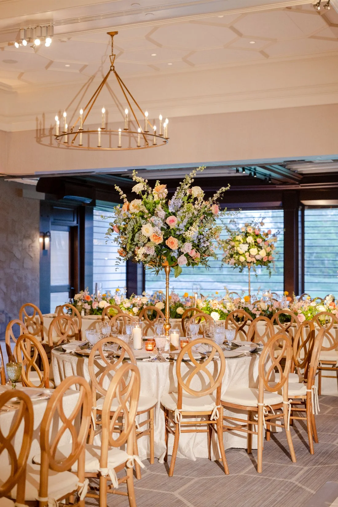 Elegant reception table set with place settings and colorful wedding flowers.