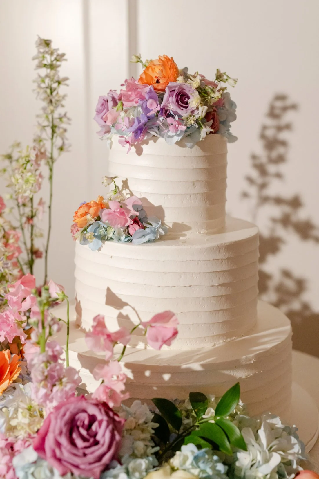Beautiful colorful wedding cake displayed at a Quaker Ridge Golf Club wedding reception.