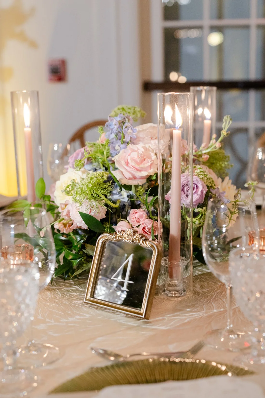 Wedding table number surrounded by colorful floral arrangements.