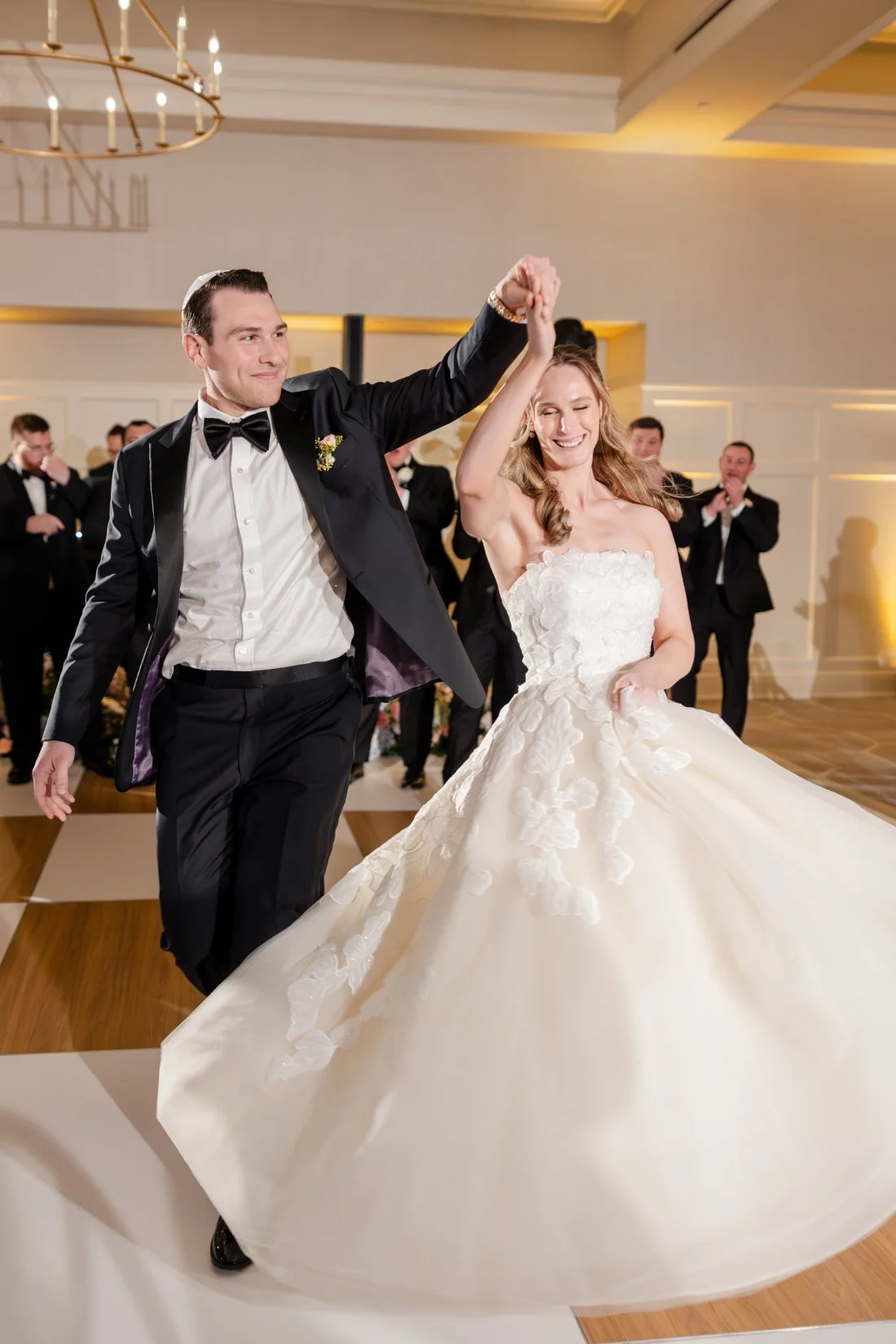 Bride and groom sharing their first dance surrounded by wedding guests.