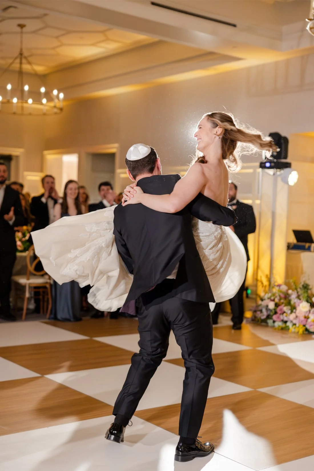 Newlyweds smiling and dancing together during their wedding reception.