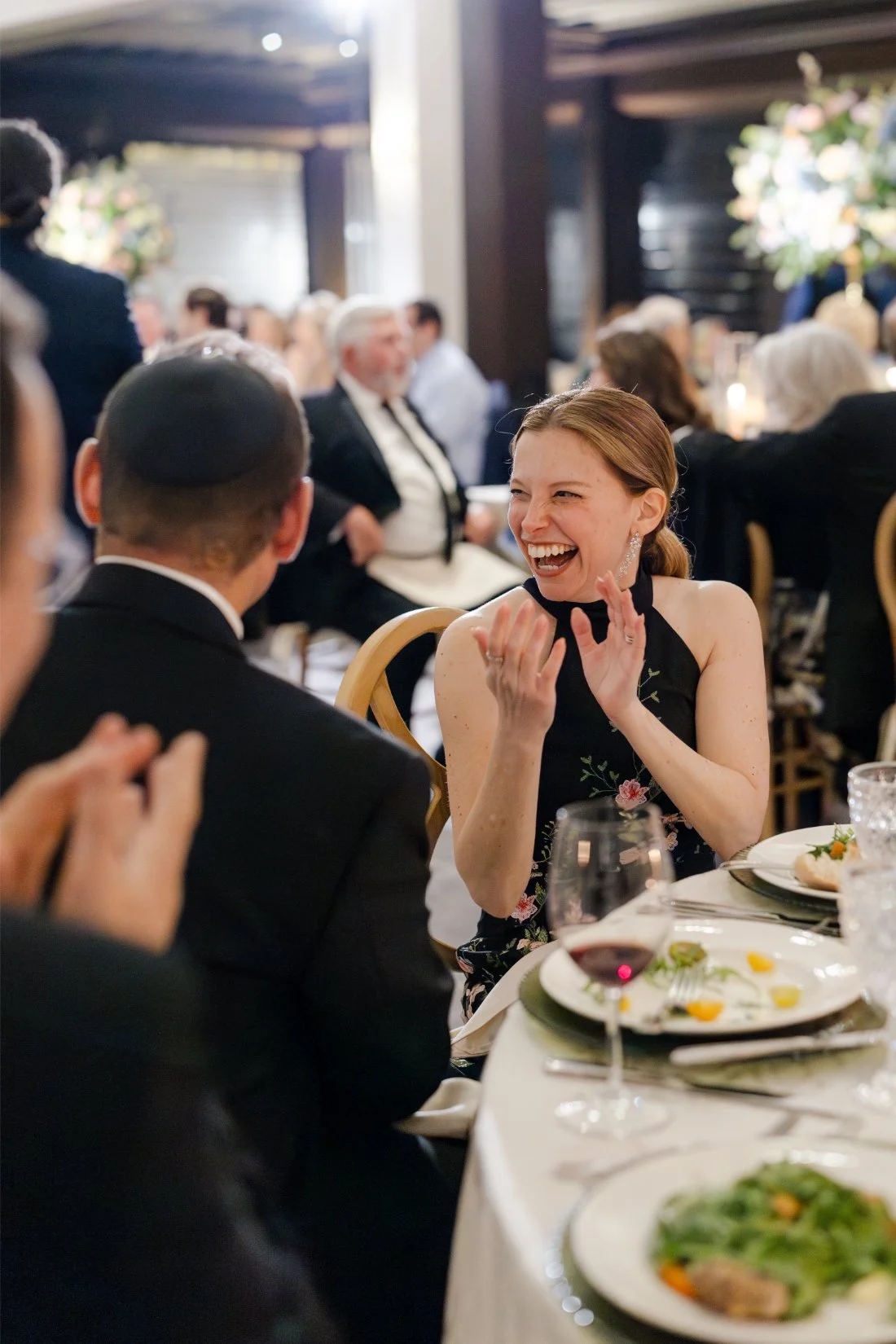 Guests laughing and reacting to a heartfelt wedding speech.