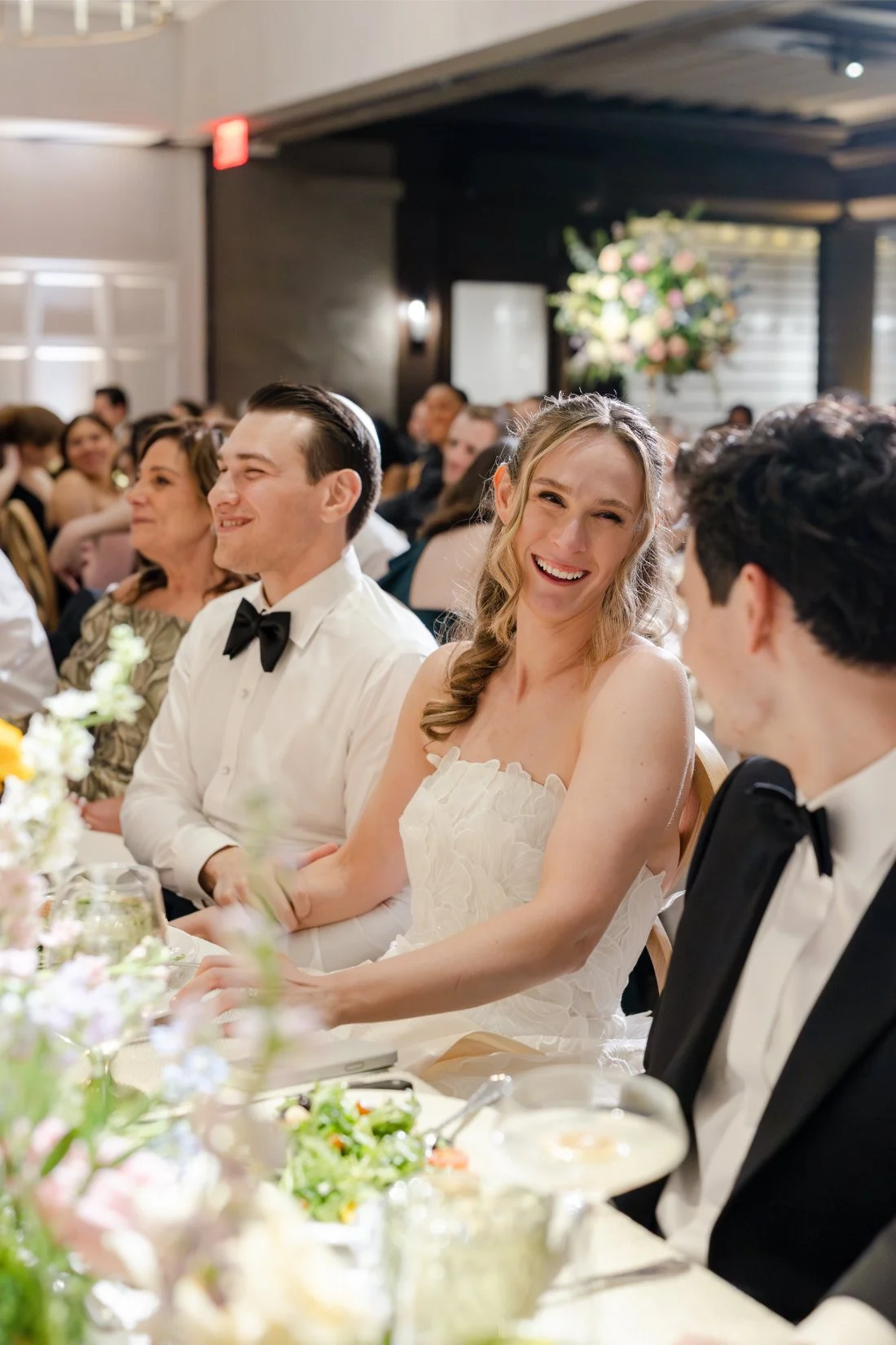 Bride smiling during speeches at her Quaker Ridge Golf Club wedding reception.