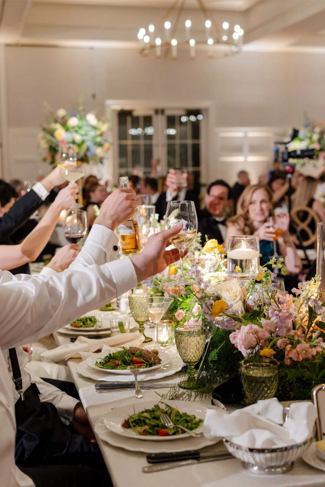 Guests raising their glasses for a celebratory wedding toast.