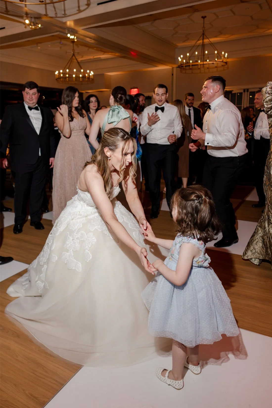 Bride dancing with the flower girl during a joyful moment at the reception.